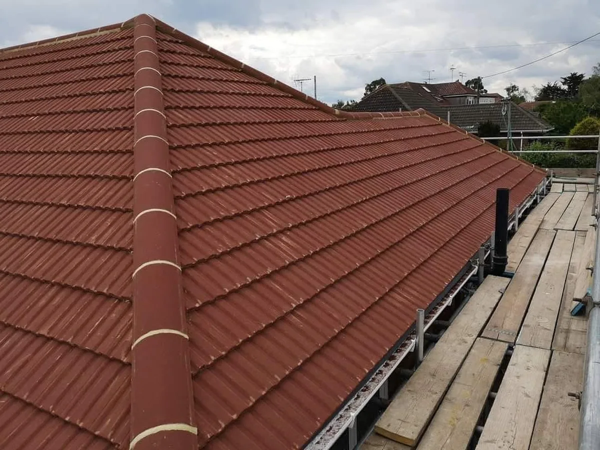 Red clay tile hip roof with new ridge tiles fitted